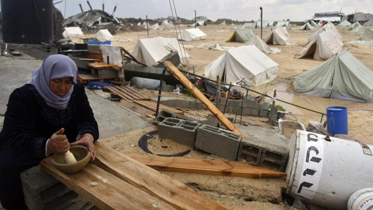 esala9980353 a palestinian woman uses a pestle and mortar at a tent camp 161215193000