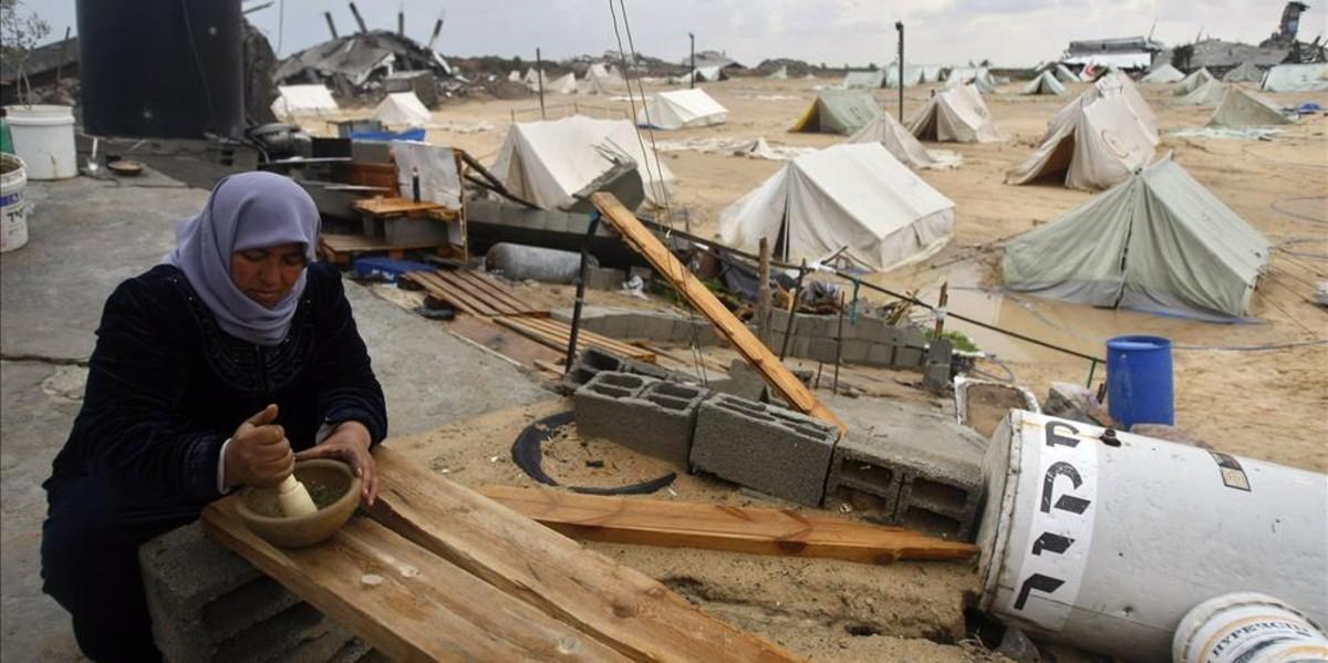 esala9980353 a palestinian woman uses a pestle and mortar at a tent camp 161215193000