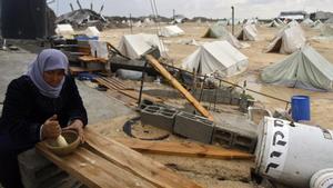 esala9980353 a palestinian woman uses a pestle and mortar at a tent camp 161215193000
