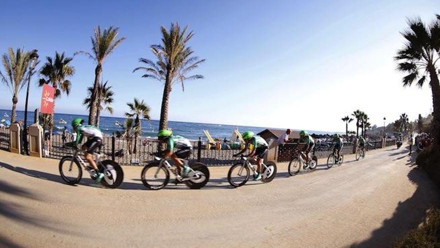 La imagen muestra a los ciclistas profesionales en su paso por el paseo marítimo de Marbella.