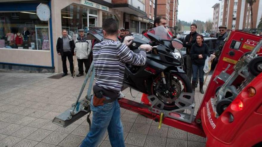 Un agente de paisano, junto a una de las motos incautadas.