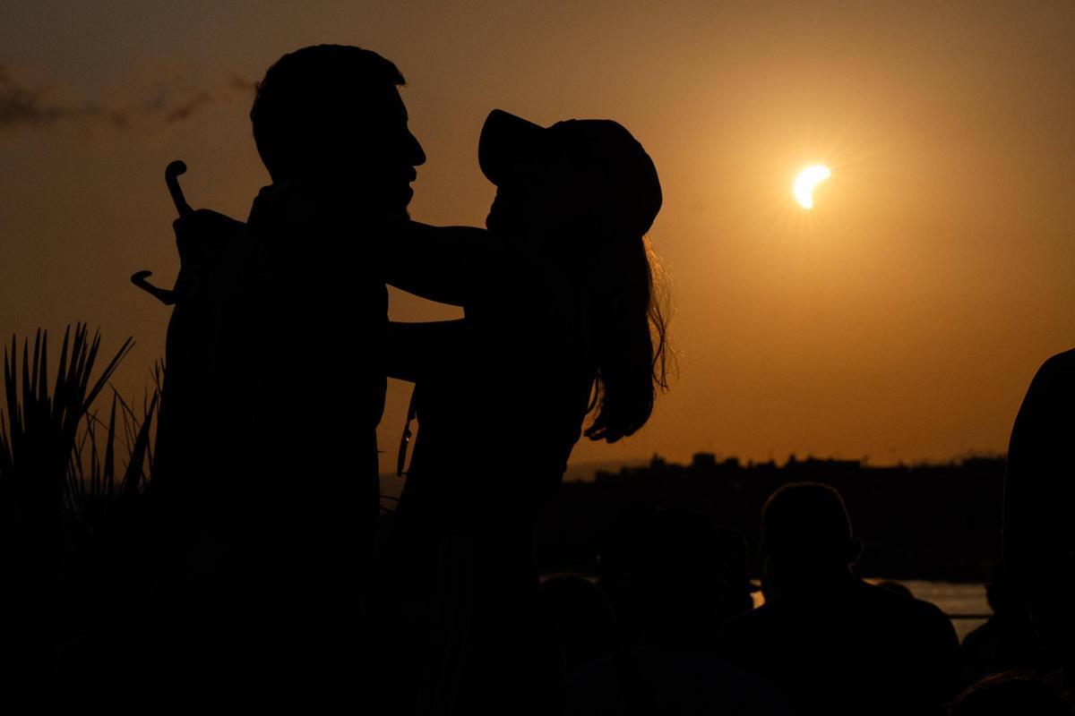 Una pareja se abraza en Tarragona, en el Port Marina Tarraco, durante la contemplación del eclipse total de Sol del 12 de agosto.