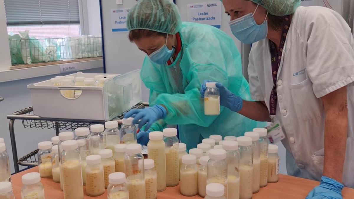 Dos enfermeras con botes de donación de leche materna