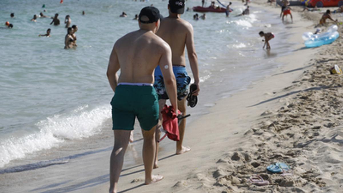 Zwei junge Männer trotzen am Strand auf Mallorca der Hitze