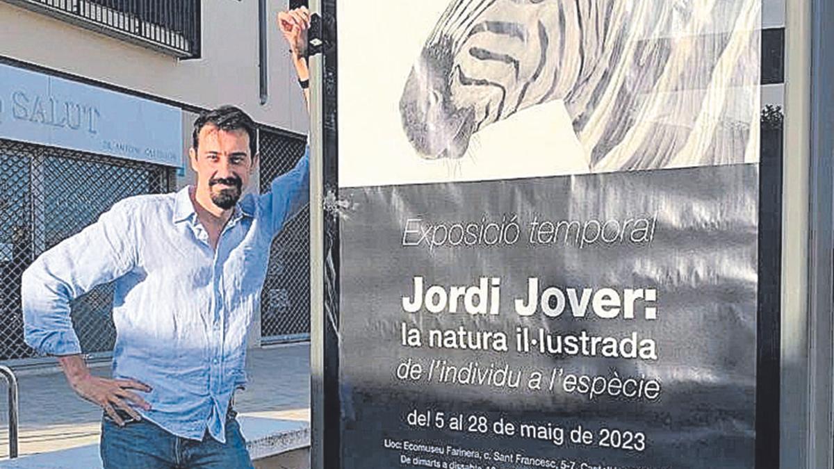 L’il·lustrador Jordi Jover amb el cartell de la seva exposició.