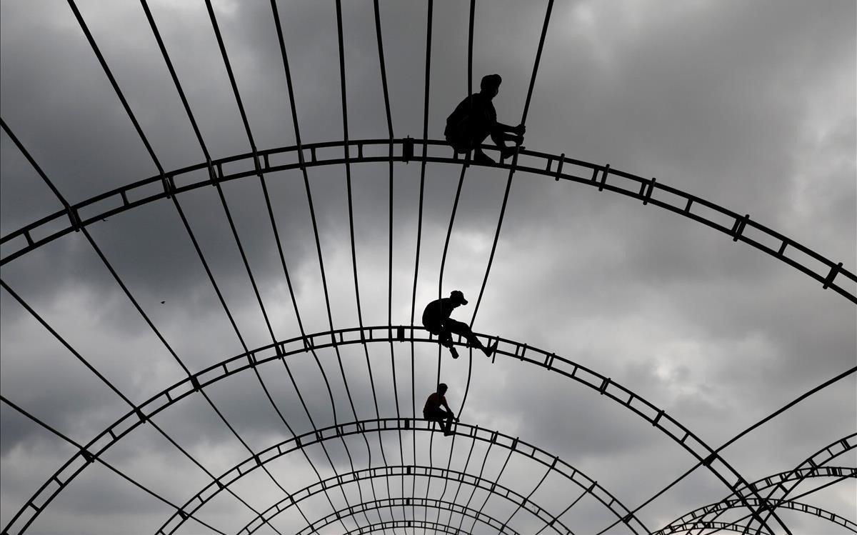 Hombres trabajando en la parte superior de una carpa en Colombo, Sri Lanka.