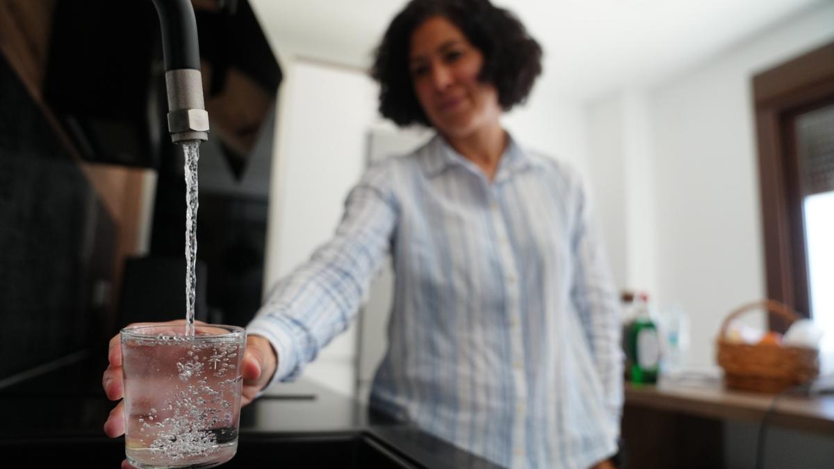 Una mujer llena un vaso de agua en Pozoblanco, Córdoba, zona que ha tenido graves problemas de suministro y abastecimiento de agua durante estos meses.