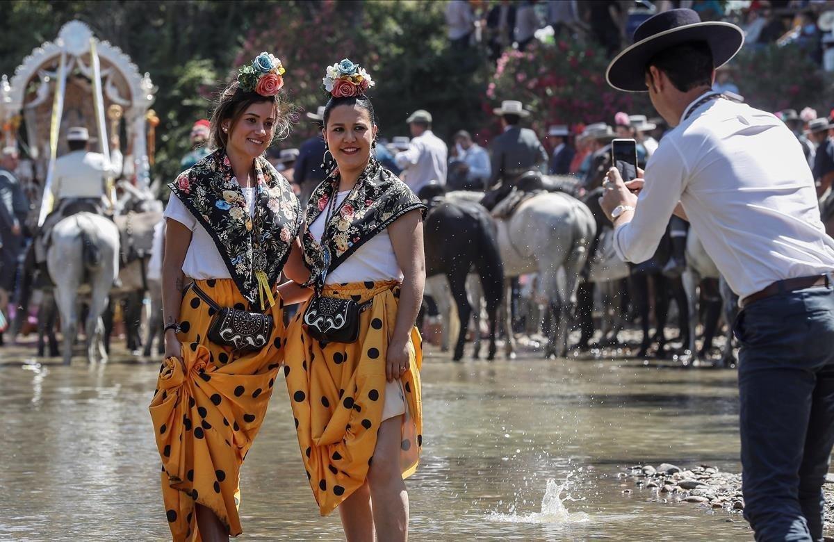 Romeras se hacen una fotografía al pasar por el Vado del Quema en ell río Guadiamar, en Aznalcázar (Sevilla). Este es uno de los puntos neurálgicos de la peregrinación; un lugar con un significado muy especial en el que se da la bienvenida a la devoción rociera a aquellos que por primera vez surcan los caminos hacia la aldea almonteña de El Rocío (Huelva) donde este fin de semana se unirán al resto de hermandades, con un total de 124, para realizar la romería de Pentecostés 2019.