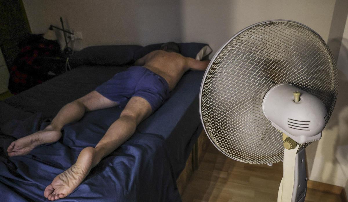 Un hombre trata de dormir este verano con un ventilador en Alicante