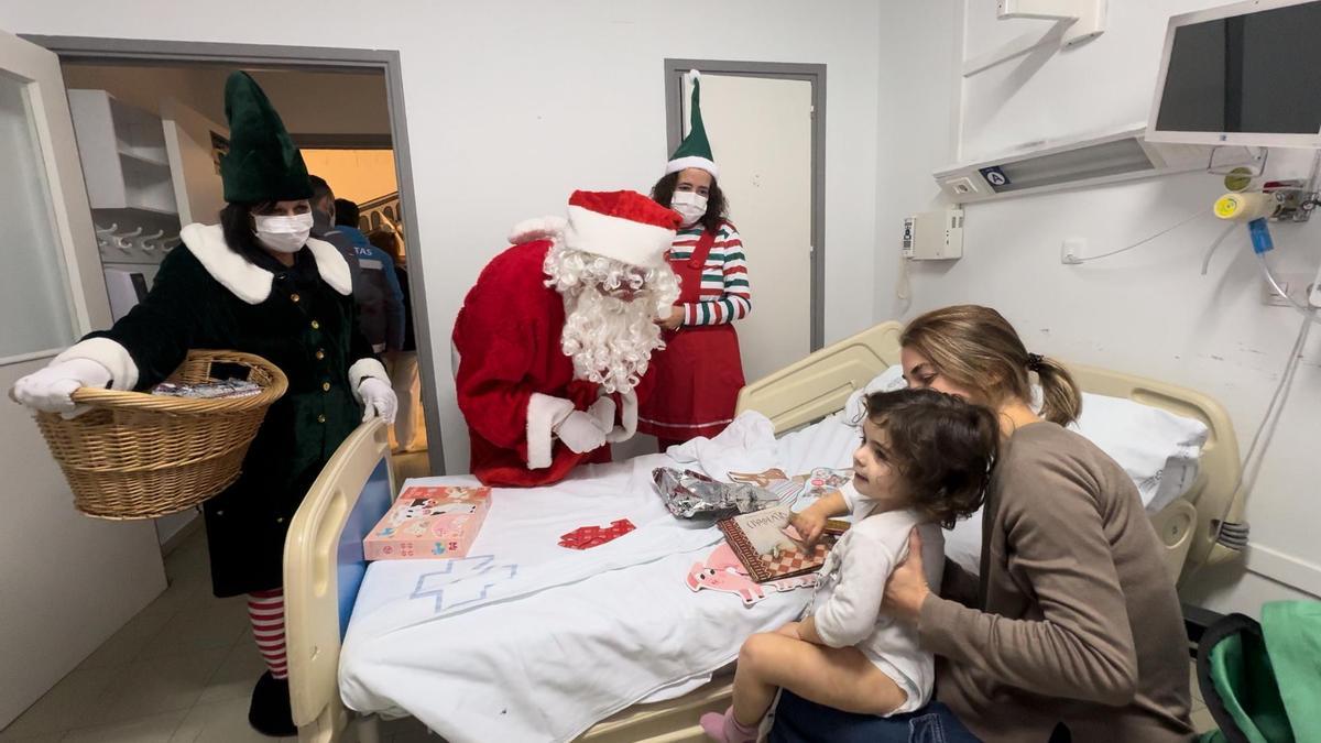 Papá Noel visita a una paciente de la planta de Pediatría del Hospital Universitario de Ourense.