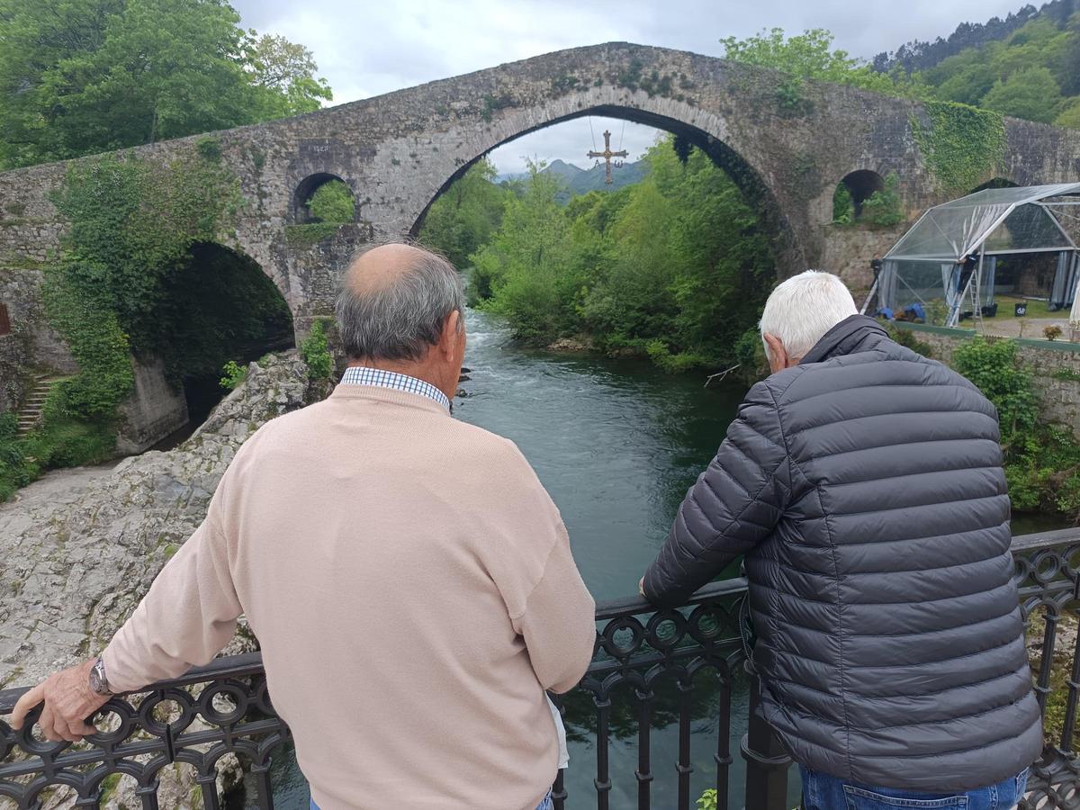 Dos vecinos observan el estado del río Sella en Cangas de Onís.