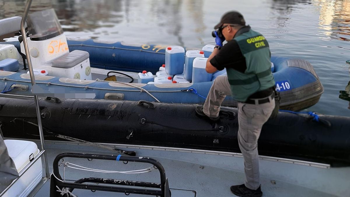 Un agente de la Guardia Civil hace fotografías a la embarcación decomisada.