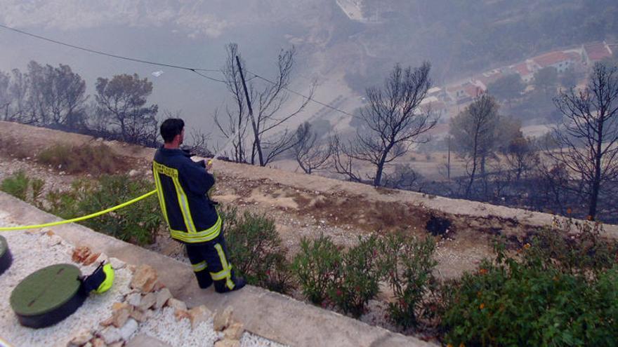 Un bombero refresca la zona en el entorno de la Granadella.