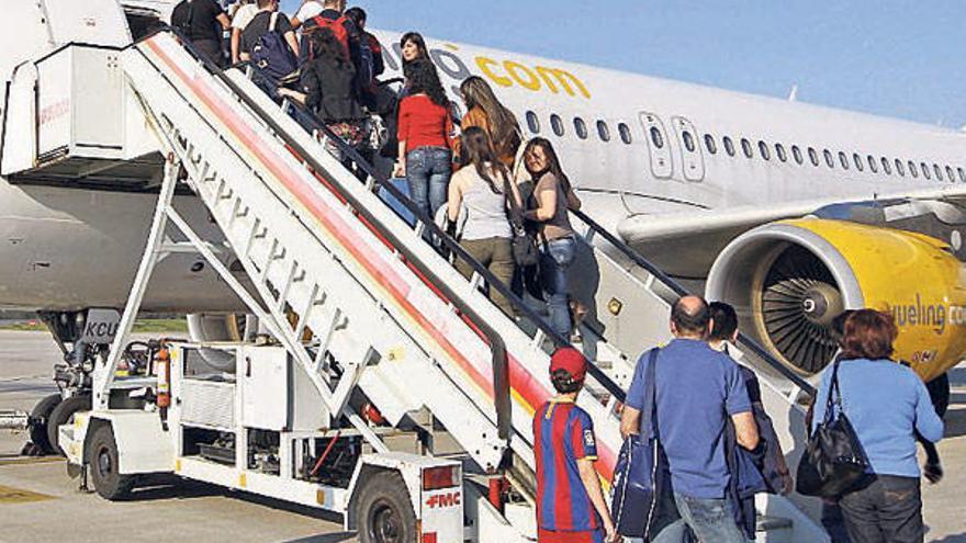 Viajeros se suben a uno de los aviones de la aerolínea Vueling en Peinador