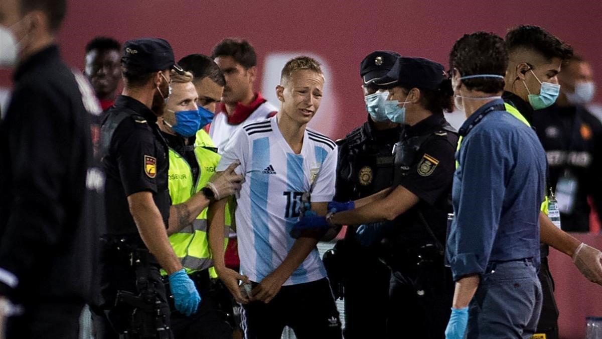 La policía saca al espontáneo del césped del estadio Visit Mallorca.