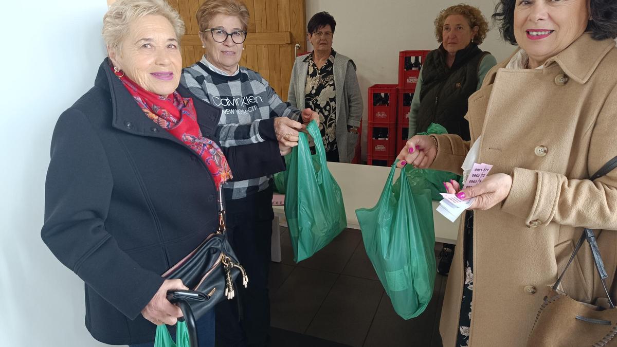 Por la izquierda, Vicenta Martínez y Oliva Fernández reciben el bollo de manos de Victoria Muñiz, vicepresidenta de la Asociación de Jubilados de Valdesoto.