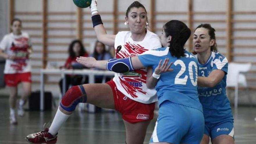 Una jugadora del Gijón es frenada por la defensa oviedista.