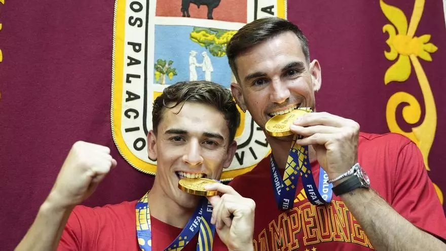 Los futbolistas de la selección española Fabián y Gavi reciben su peso en kilos de tomate