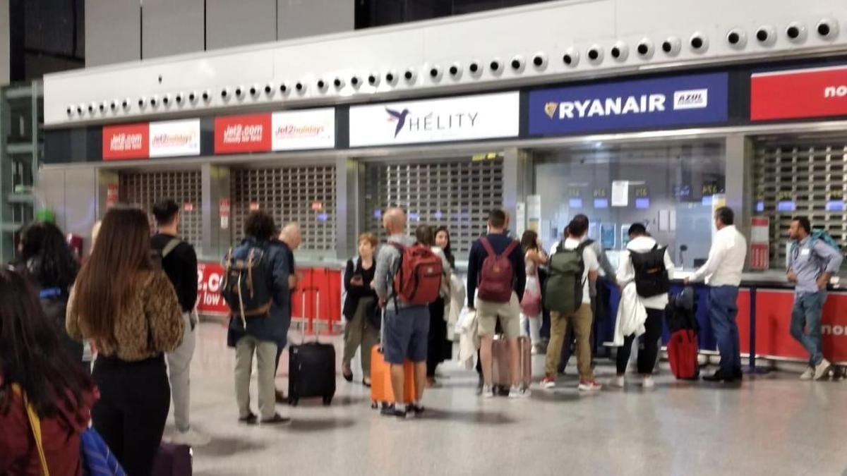 Pasajeros afectados por la cancelación, ayer en el aeropuerto de Málaga frente al mostrador de Ryanair.