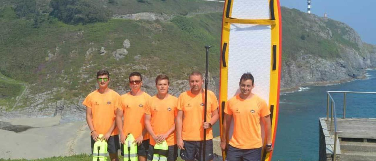 El equipo de salvamento de Coaña, en la playa de Arnelles, con la tabla de paddle surf.