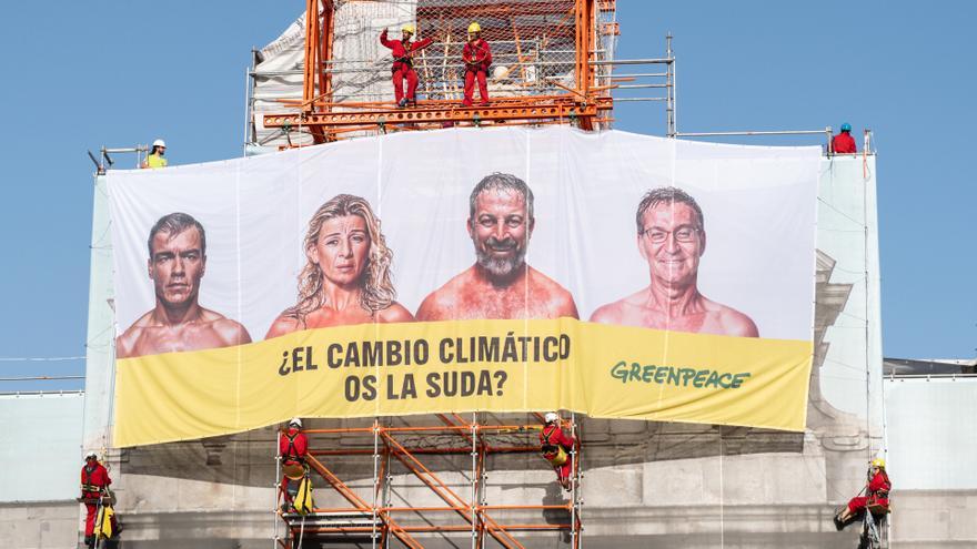 La Puerta de Alcalá amanece tapada por una pancarta con la cara de los candidatos y la frase: “¿El cambio climático os la suda?”