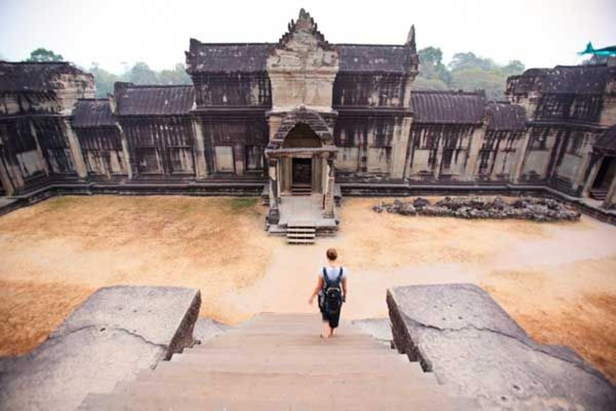 Una turista baja las escaleras hacia uno de los templos de Angkor Wat.