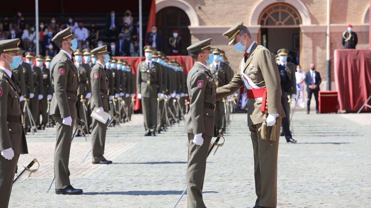 El Rey coloca una medalla a uno de los mejores alumnos de la nueva promoción.