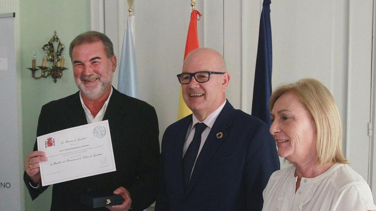 Anxo Quintana sostiene el diploma del premio,  acompañado por Eladio Santos y la responsable de Igualdad de la Subdelegacion.