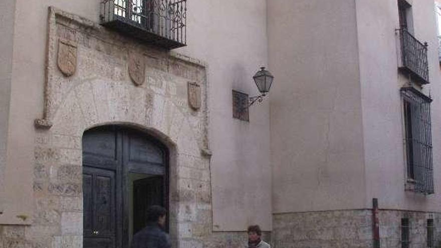 Vecinos pasean junto al acceso principal de la Casa de Cultura.