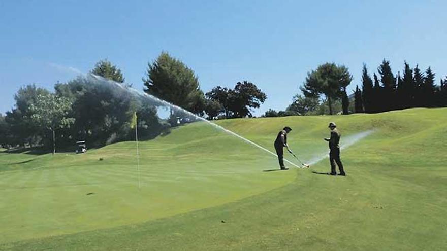 Dos agentes de Medio Ambiente comprueban el sistema de riego de un campo de golf.