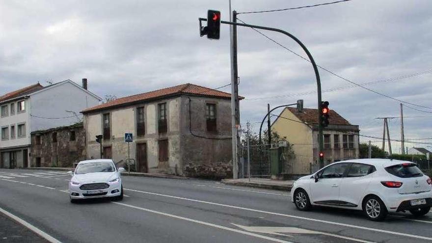 Dos coches circulan por el cruce del semáforo de Lañas.