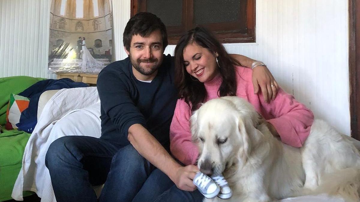 Marc y Sandra, con su perro Pep, muestran los zapatitos de bebé en el mensaje que confirma el embarazo.