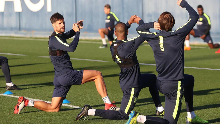 Adrián González, jugador del Málaga CF, realiza ejercicios en el Anexo de La Rosaleda junto a Rolan e Ignasi Miquel, ambos de espaldas.