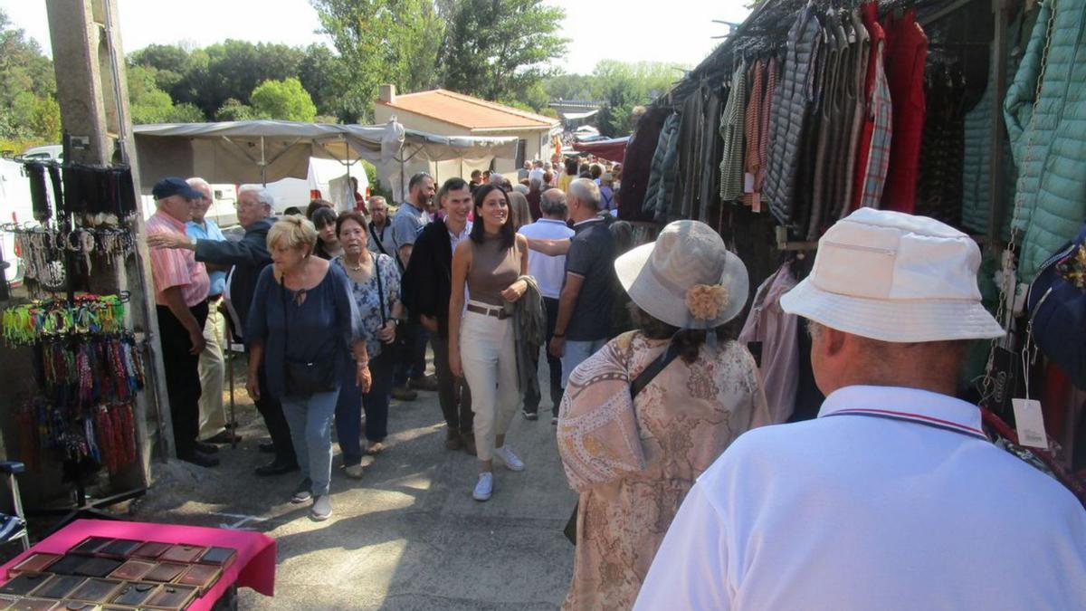 Participantes recorren los puestos del mercado en la romería. | E. R.