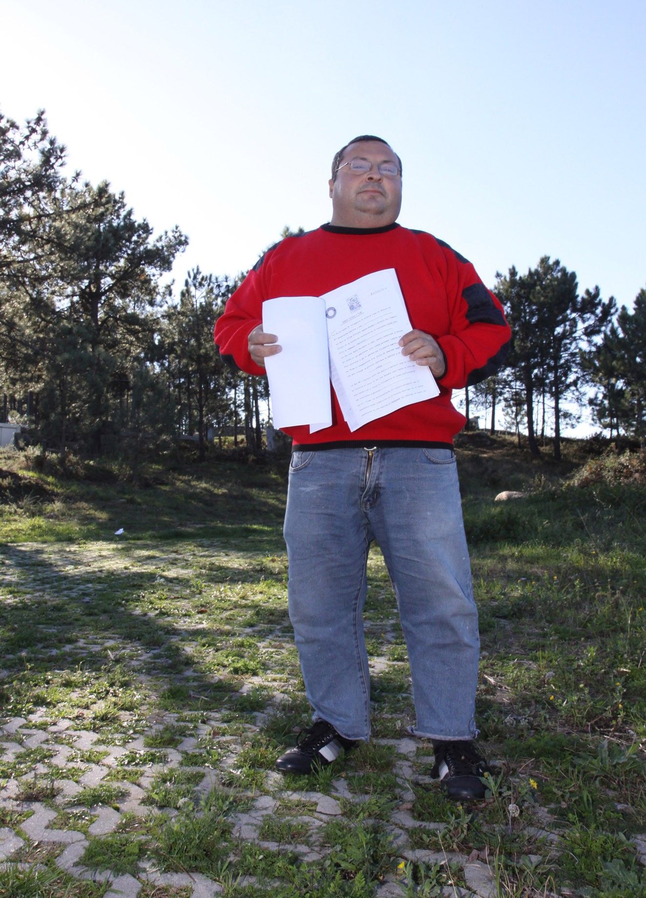 El vecino con algunos de los documentos que mostró en 2011 como prueba de que es el titular del terreno.