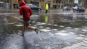 Un hombre cruza corriendo la avenida Diagonal.