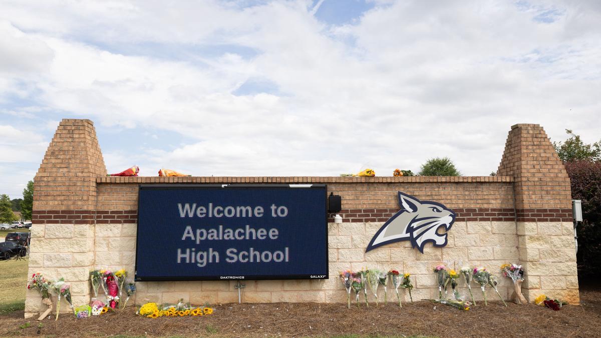 WINDER, GEORGIA - SEPTEMBER 5: The entrance sign of Apalachee High School adorned with flowers from visitors on September 5, 2024 in Winder, Georgia. Two students and two teachers were shot and killed at the school on September 4, and a 14-year-old suspect, who is a student at the school, is in custody. Jessica McGowan/Getty Images/AFP (Photo by Jessica McGowan / GETTY IMAGES NORTH AMERICA / Getty Images via AFP)