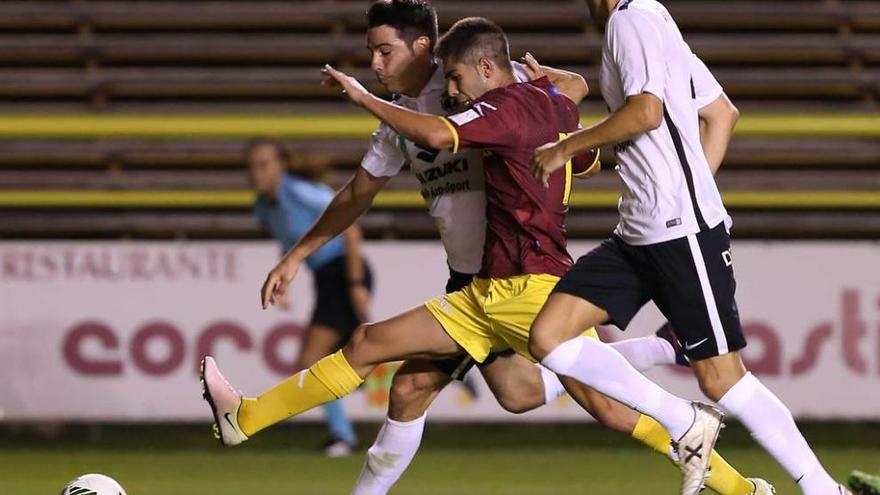 Roni trata de llegar al balón ante dos jugadores del Burgos.