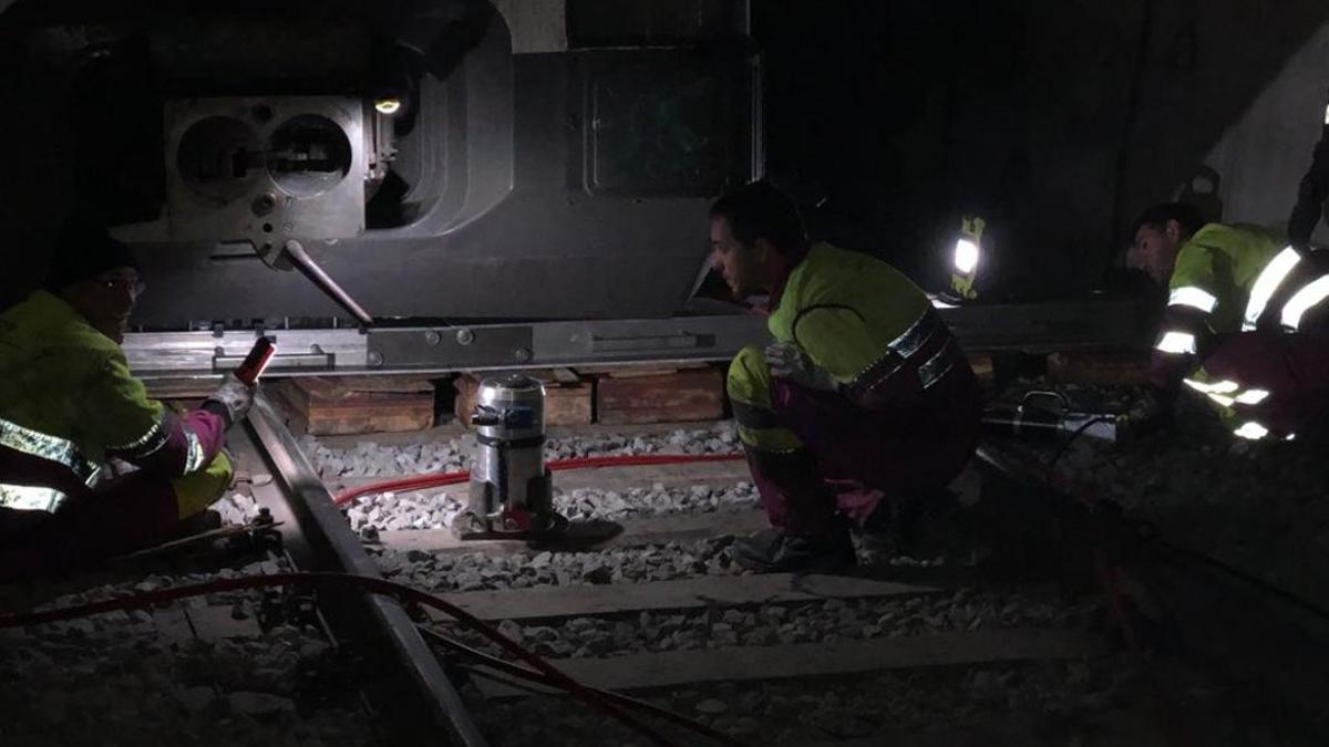 Técnicos de Renfe trabajan para encarrilar el tren accidentado en el túnel de Toses