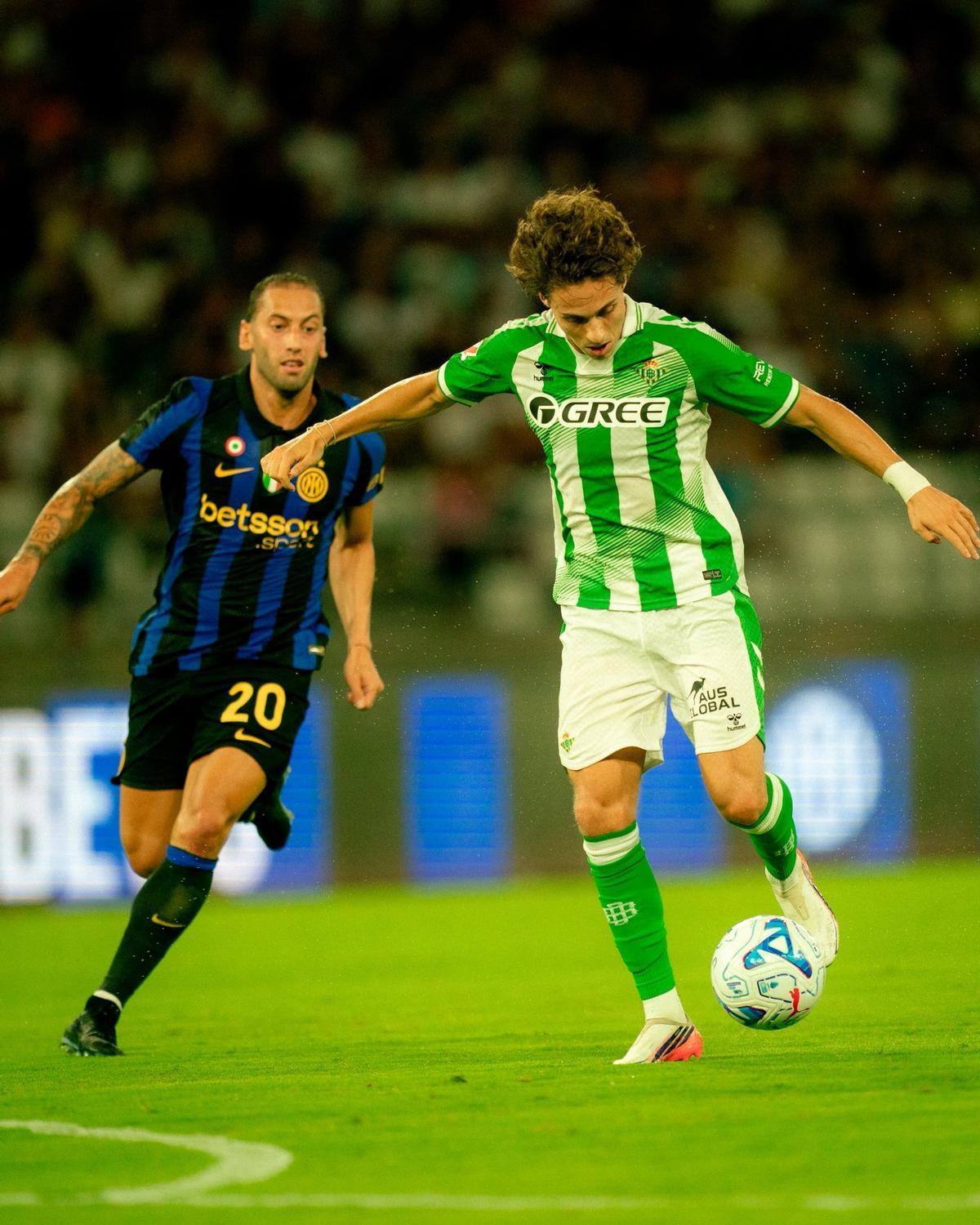 Roro Riquelme juega un balón ante Calhanoglu en el amistoso entre Inter y Betis en Bari