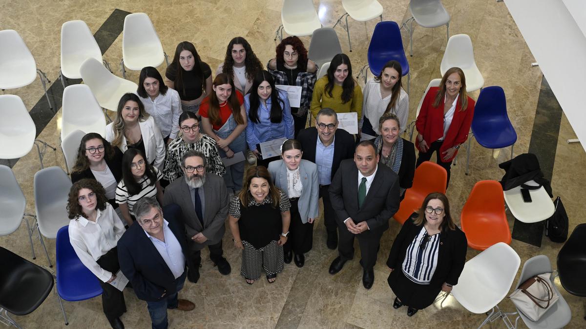 Las beneficiarias de las becas posan tras la entrega del diploma con el rector, la vicerrectura de Estudiantes, el director general de Unviersidades y los decanos y decanas de sus facultades