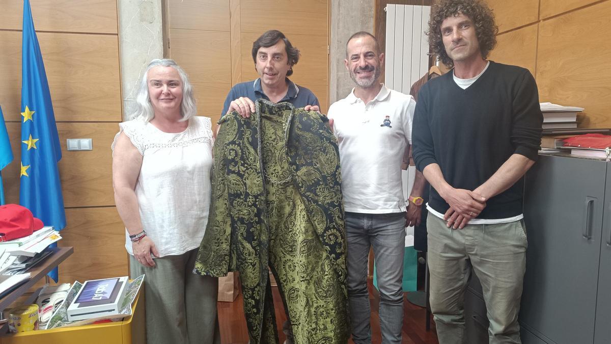 Eva María Pérez, Gerardo Sanz, Ángel García e Iván Pérez, en la entrega de la capa de Exconxuraos al alcalde de Siero.