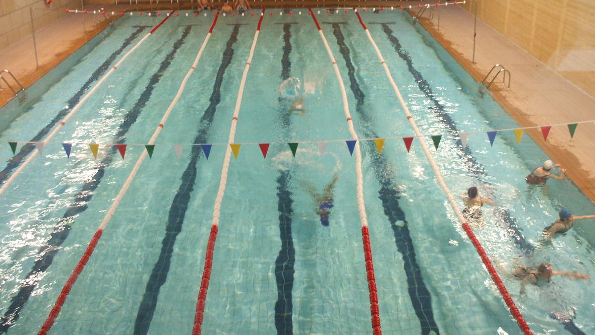 Bañistas nadan en la piscina cubierta en una temporada previa a su cierre
