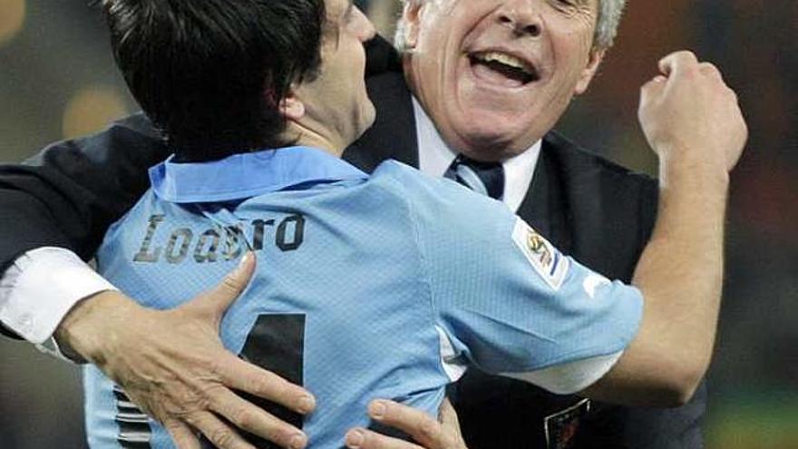 El seleccionador de Uruguay abraza a un jugador.