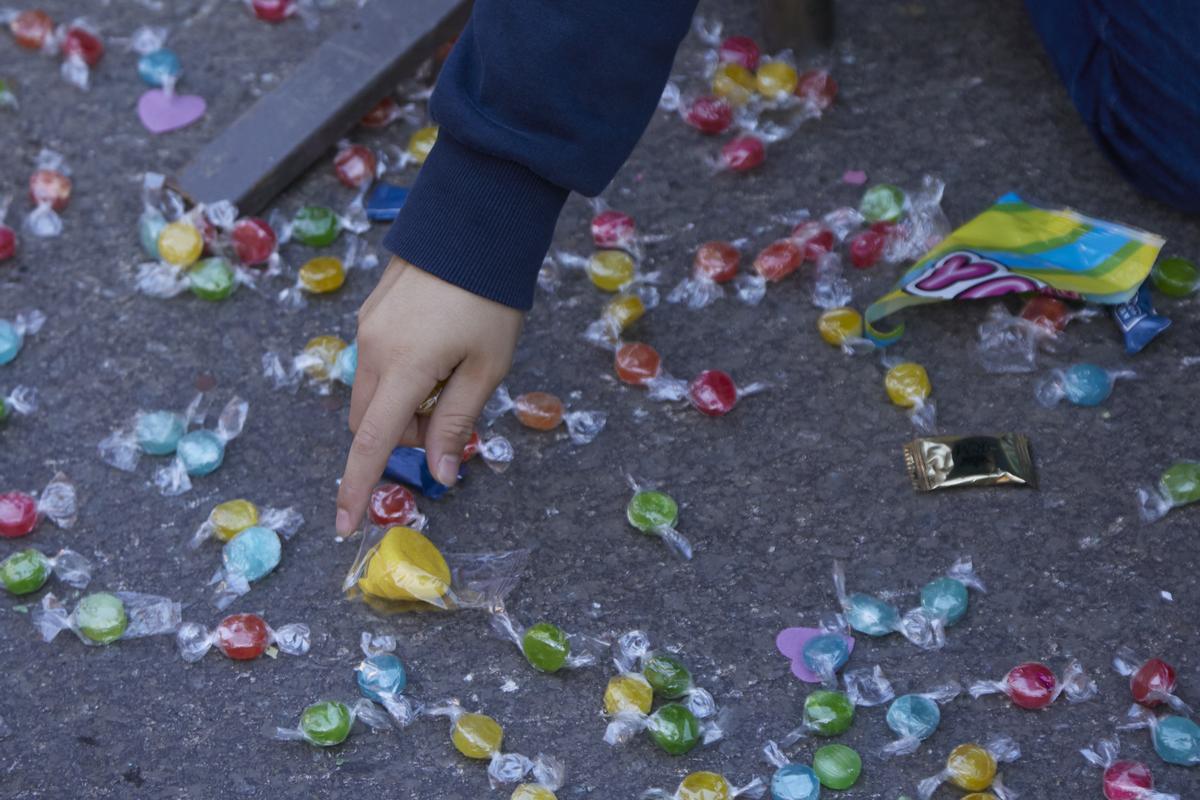 Detalle de la mano de un niño cogiendo caramelo durante la cabalgata de SSMM Los Reyes Magos.