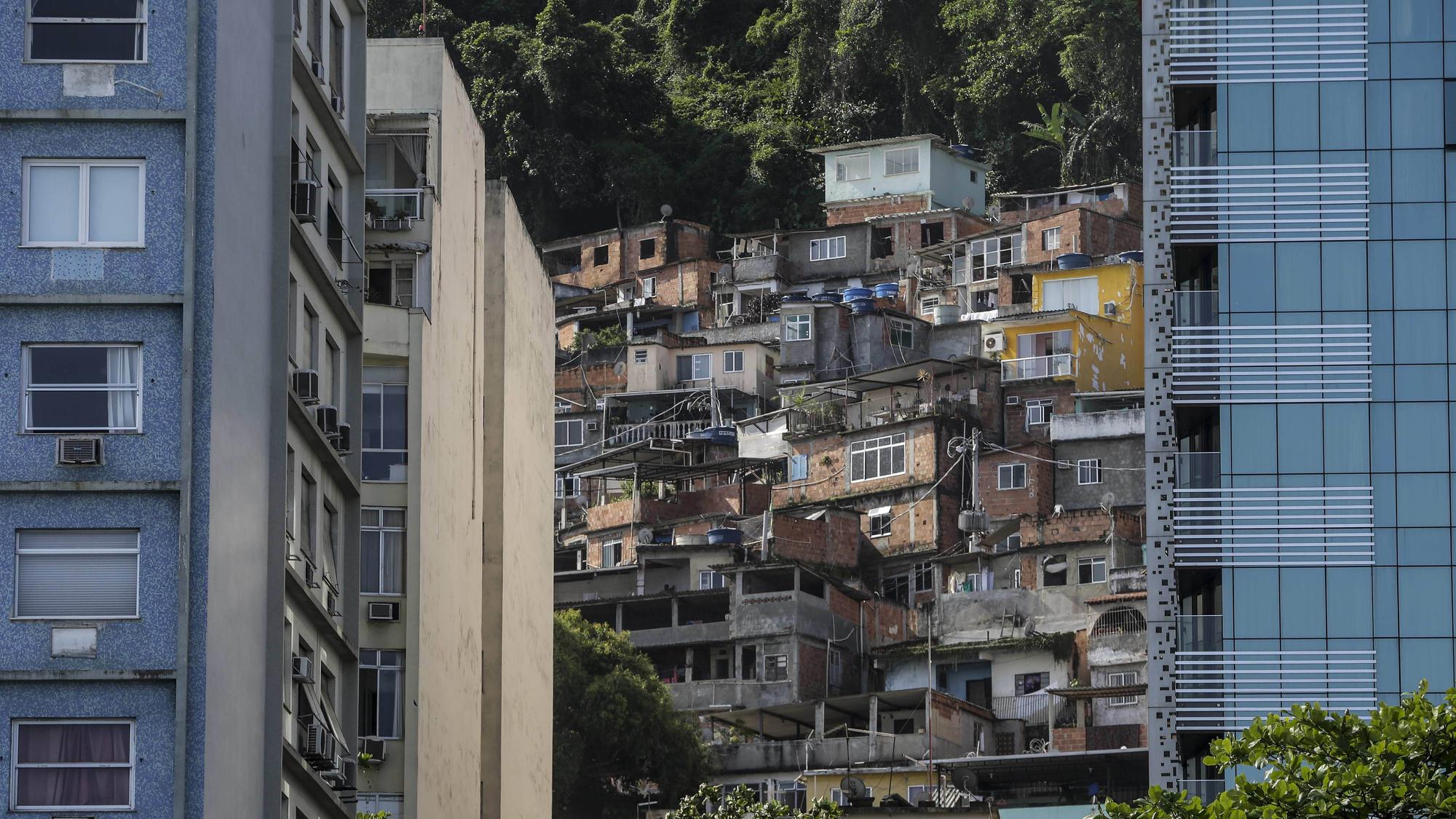 En la playa de Copacabana, en Brasil, la vista de los edificios de lujo choca con la imagen de las favelas que se vislumbran en el fondo.