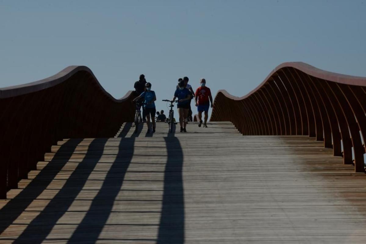 Peatones en la pasarela que cruza el Guadalhorce.