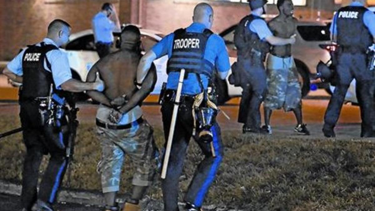 Los choques 8 La policía arresta a unos manifestantes mientras siguen las protestas en Ferguson.