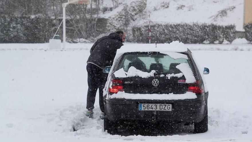 Un conductor retira la nieve del parabrisas de su coche en pasado día 23 en Pedrafita do Cebreiro / Carlos Castro // E.P.