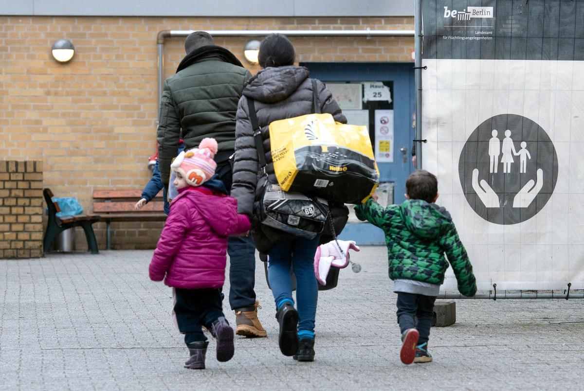 Ein Flüchtling geht mit seiner Familie auf dem Gelände der Erstaufnahmeeinrichtung des Landesamtes für Flüchtlingsangelegenheiten (LAF) in Reinickendorf.